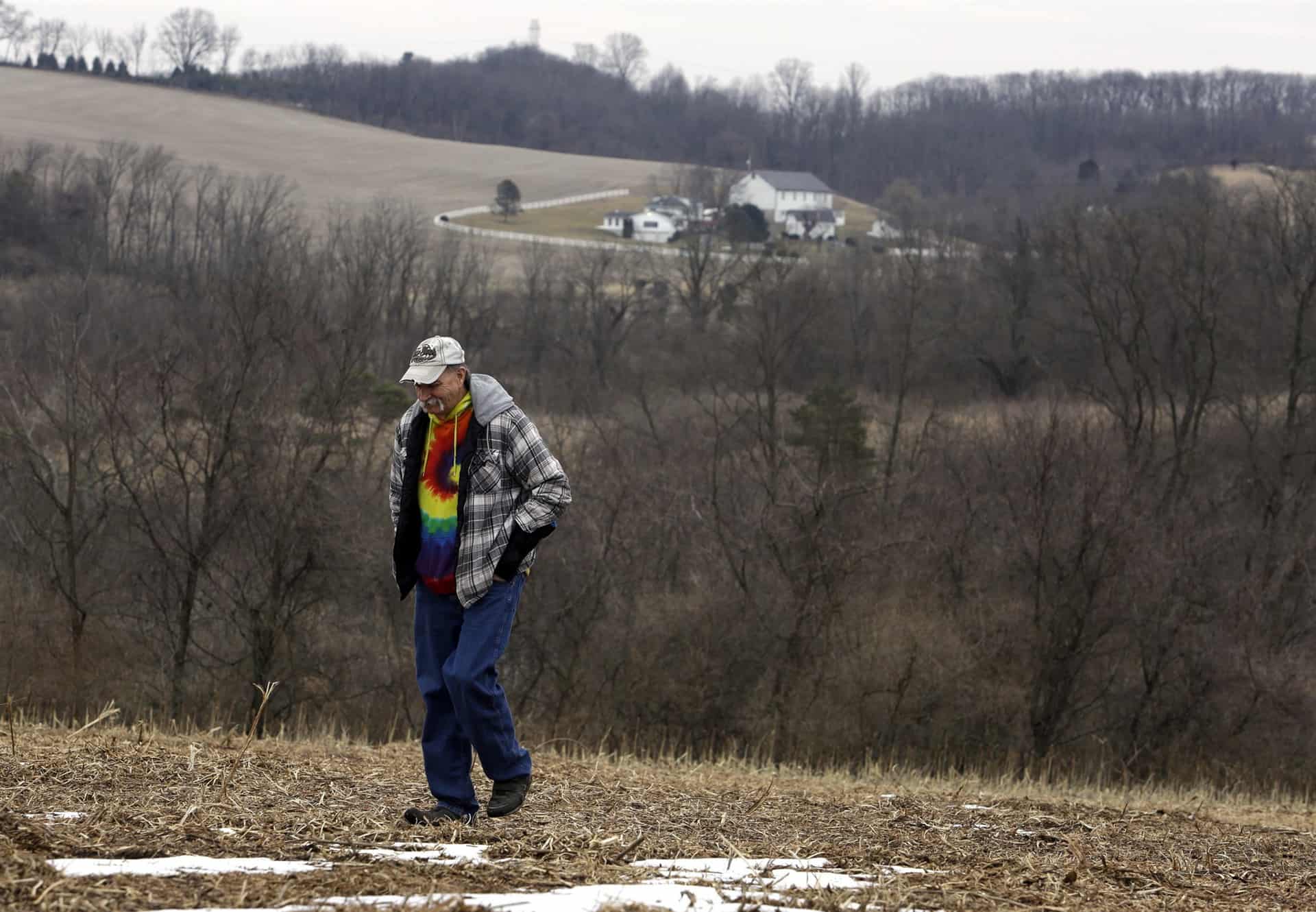 The uncle of Greg Longenecker, walks in the field where Longenecker was killed by a bulldozer in Bernville, Pennsylvania.